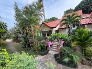 a house with palm trees in front of it at Mae Somboon House in Lamai