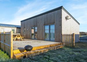 a wooden house with a grill on a wooden deck at Castle Pren Lodges in Llanddewi Ystradenny +10 photos