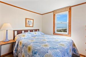 a bedroom with a bed and a window at 4020 - Gardners Hut in Kitty Hawk Beach