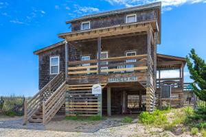 a log cabin with a sign that reads brothers hill at 4020 - Gardners Hut in Kitty Hawk Beach +35 photos