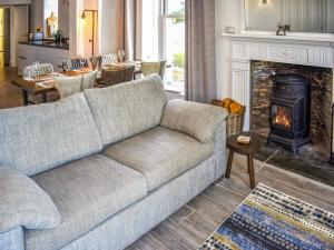 een woonkamer met een bank en een open haard bij Cedars in Mortehoe