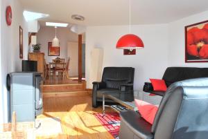 a living room with black chairs and a glass table at Ferienwohnung Warnemünde Altstadt (RC) in Warnemünde