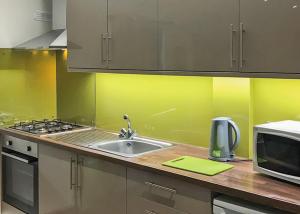 a kitchen with a sink and a microwave at Beech Hedge in Coupar Angus +8 photos