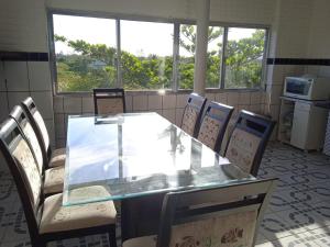 Pousada Refúgio Natural da Ilha في إلها كومبريدا: غرفة طعام مع طاولة وكراسي زجاجية