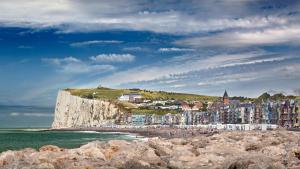 L'Art Pop - Chic & Coloré Plage à 5 min en voiture في Biville-sur-Mer: مجموعة من المباني على شاطئ بجوار المحيط