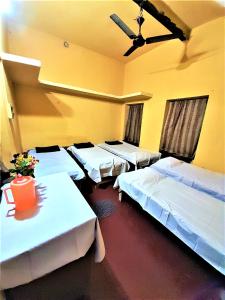 a room with three beds and a ceiling at The OLD house in Bolpur