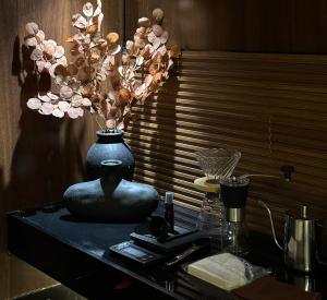 Eine schwarze Vase mit Blumen auf dem Tisch. in der Unterkunft استديو هادئ بدخول ذكي in Ar Rass