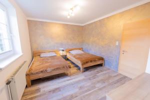 zwei Betten in einem Zimmer mit Holzboden in der Unterkunft Apartmenthaus 113 in Stadl an der Mur