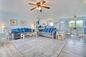a living room with blue furniture and a ceiling fan at 4140 - Beach Carousel in Kitty Hawk