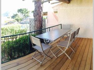 a wooden deck with a table and two chairs at Les Mini-villas de Santa-giulia in Porto-Vecchio