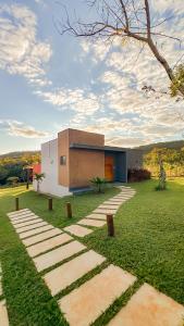 Loft Cerrado de Minas في جوبوتيكاتوباس: منزل في وسط حقل أخضر مع مبنى