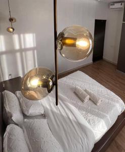 Una cama con dos luces encima. en Kampala Apartments, en Kampala