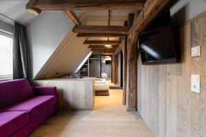 a living room with a purple couch and a tv at Ranunkelhof in Pirna