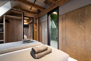 two beds in a room with wooden walls at Ranunkelhof in Pirna