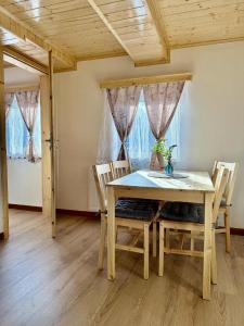 a dining room with a wooden table and chairs at Apartmány u náměstí in Chřibská