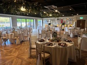 a room full of tables and chairs with white tablecloths at Holiday Inn Newcastle Gosforth Park by IHG in Newcastle upon Tyne +211 photos