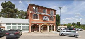 un edificio marrone con macchine parcheggiate di fronte di Pensión San Cristóbal by Bossh! Hotels a Cuenca