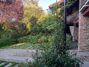 a garden next to a brick building at Rosedeliziose B&B Baldissero Canavese in Torre Canavese