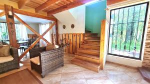 a living room with wooden stairs and a large window at Nido Del Bosque in Pucón
