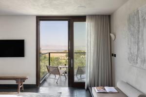 a living room with a sliding glass door with a balcony at Pereh Mountain Resort in Gadot