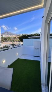 a white balcony with a green lawn on it at Las Americas 200A apartment in Costa de Adeje