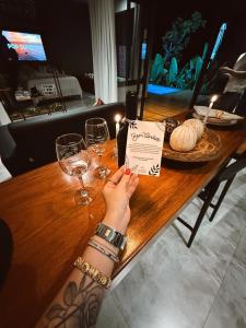 Loft Cerrado de Minas في جوبوتيكاتوباس: شخص يحمل زجاجة نبيذ على طاولة