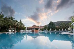 a large pool of blue water in front of a resort at Lycus River Thermal Hotel in Pamukkale