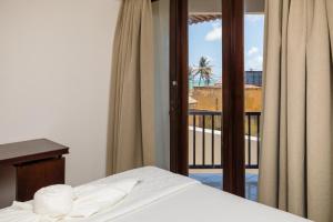 a bedroom with a bed and a view of a balcony at Sirius Beach Hotel in Natal +53 photos