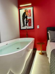 Doce Refúgio BV , Estacionamento, Piscina , Bela Vista في ساو باولو: حوض استحمام في غرفة بجدار احمر