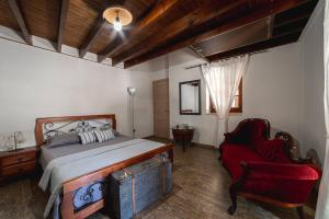 a bedroom with a bed and a red chair at Villa To Palati with Private Pool Anogyra in Anoyira +30 photos