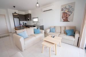 a living room with two couches and a table at Hubstay Tamara Gardens 2 Bed Apt Suite with Pool in Livadhia