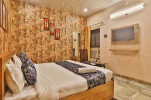 a hotel room with a bed and a flat screen tv at Hotel Kasol Heritage in Lucknow