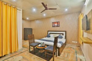 a bedroom with a bed and a table and chairs at Hotel Kasol Heritage in Lucknow