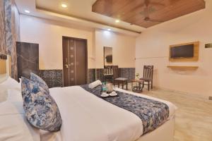 een hotelkamer met een bed en een tv bij Hotel Kasol Heritage in Lucknow +48 foto's
