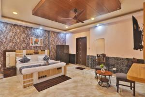 a bedroom with a king sized bed and a table at Hotel Kasol Heritage in Lucknow