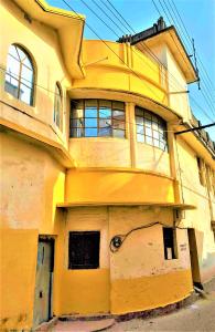 a yellow building with windows on the side of it at The OLD house in Bolpur