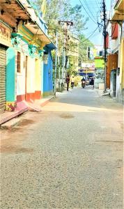 an empty city street with a person walking down the street at The OLD house in Bolpur +21 photos