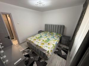 una piccola camera da letto con un letto con un piumone floreale di Casă Dulcu a Craiova