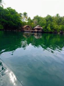 Un gran cuerpo de agua con dos chozas en él. en Shandy Sea, en Besir