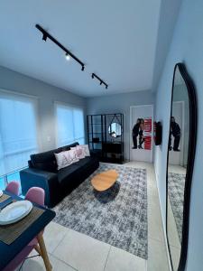 Doce Refúgio BV , Estacionamento, Piscina , Bela Vista في ساو باولو: غرفة معيشة مع أريكة سوداء وطاولة