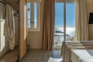 a hotel room with a bed and a view of the ocean at Atlantic Island Suites in Astypalaia
