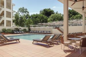 a patio with chairs and a pool with tables and chairs at Alua Linda Mallorca in Can Pastilla