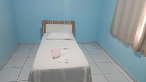 Una cama en una habitación azul con dos vasos encima. en Hotel BR, en Videira