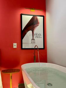 Doce Refúgio BV , Estacionamento, Piscina , Bela Vista في ساو باولو: حمام به حوض استحمام وصورة لحذاء بكعب عالٍ