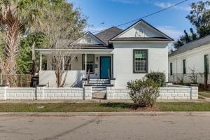 a white house with a blue door on a street at 2 Mi to Dtwn Jax Game-Ready Retreat with Yard in Springfield