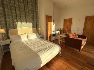 a bedroom with a bed and a chair and a desk at Speuran Mora in Saasaig +3 photos