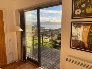 a room with a door to a balcony with a view at Speuran Mora in Saasaig