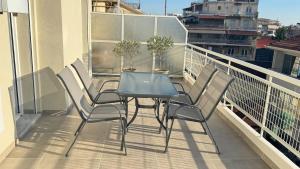 a table and chairs on the balcony of a building at Karanasiou Apartment in Tríkala