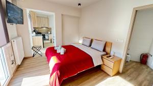 a bedroom with a large bed with a red blanket at Karanasiou Apartment in Tríkala