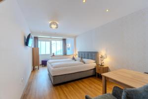 a hotel room with a bed and a table at Appartementhaus Christophorus in Obertauern